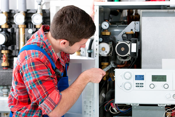 Heating technician repairing boiler controls in Simi Valley