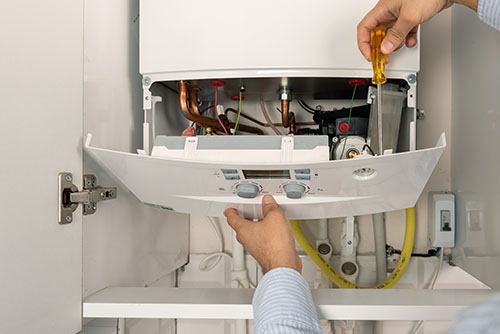 Heating technician repairing a residential boiler in Simi Valley
