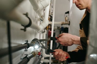 Technician inspecting commercial plumbing pipes in Simi Valley