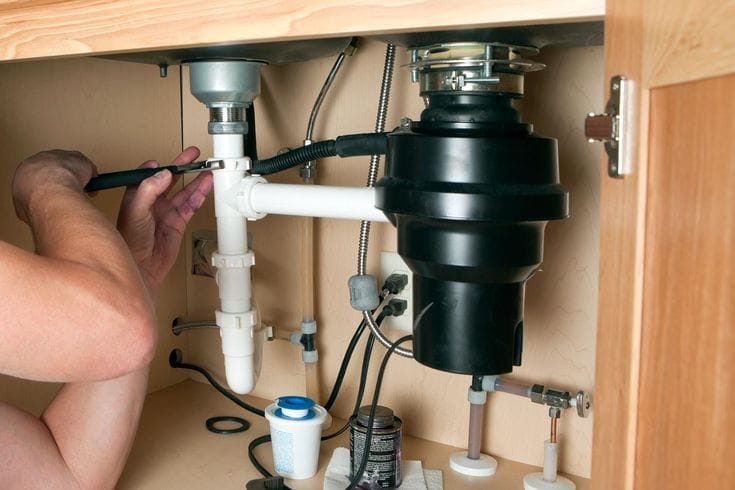 Plumber repairing a garbage disposal in Simi Valley