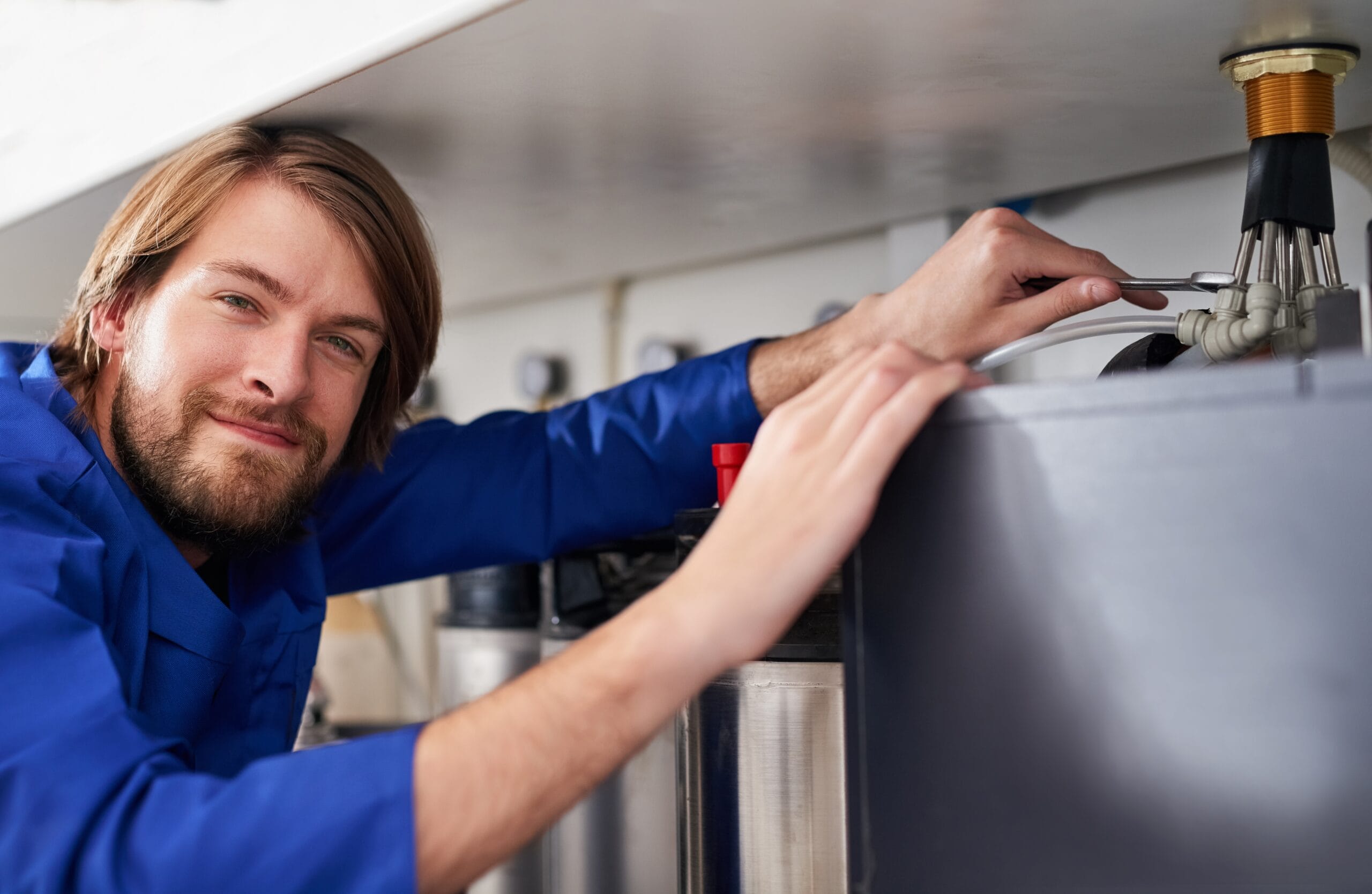 Technician servicing a residential water heater tank in Simi Valley